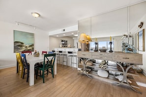 Une cuisine moderne avec un coin repas, un grand miroir et une vue sur la plage.