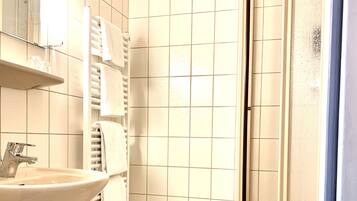 Un bagno con lavandino, specchio, asciugamano e water.