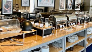 En buffé med olika matstationer, inklusive en kaffestation och en salladsbar.