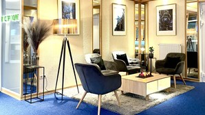 Ett modernt receptionsområde med en receptionsdisk, inramade konstverk och bekväma sittplatser.
