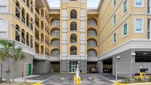 Un edificio de varios pisos con un patio central, balcones y un garaje.