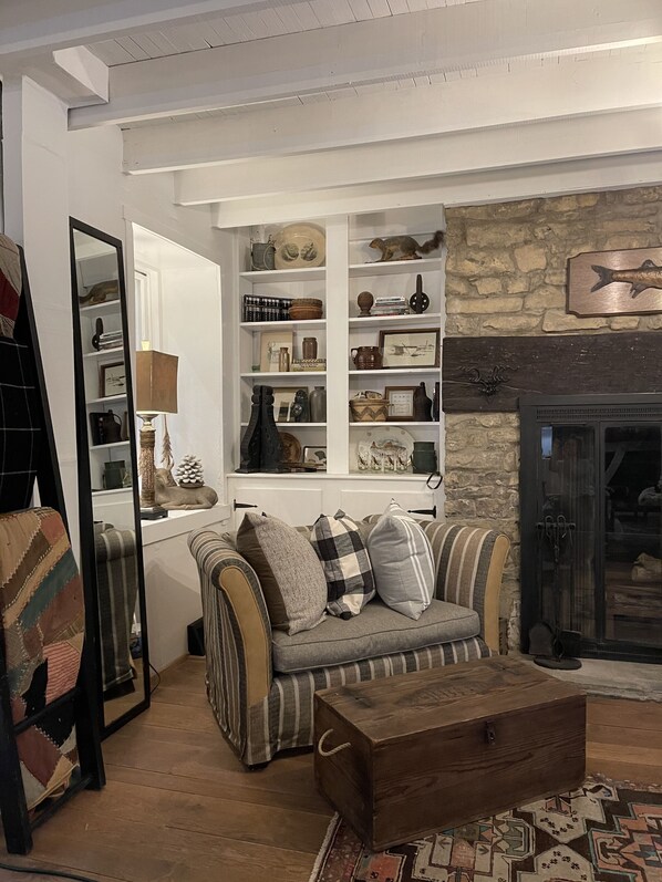 Una sala de estar acogedora con un sofá, una mesa de centro de madera y una chimenea.