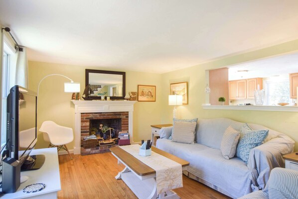 A living room with a fireplace, a sofa, a coffee table, and a television.