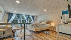 Ein gemütliches Schlafzimmer mit Bett, Schreibtisch und Fernseher.