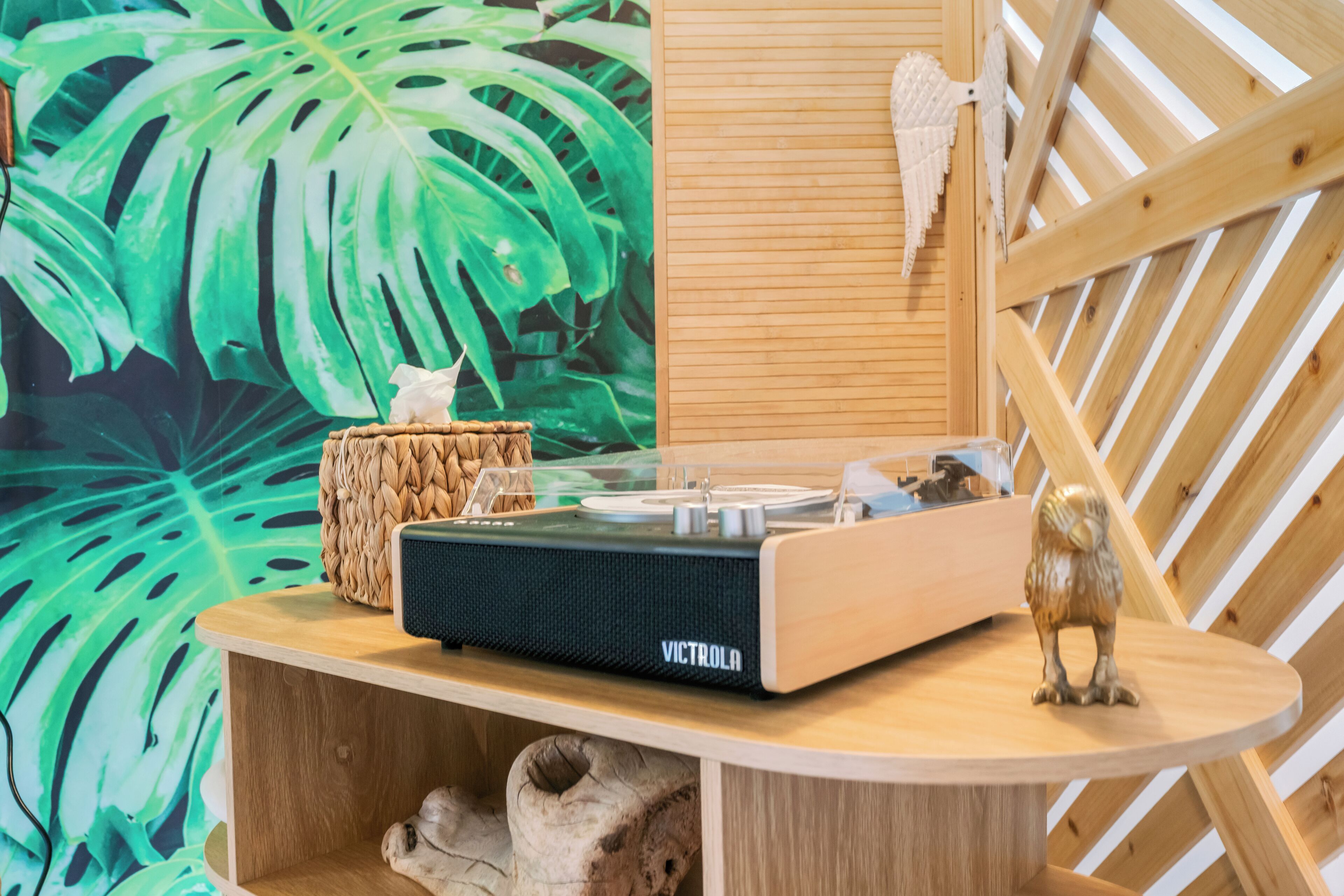 A wooden table with a black speaker labeled "VICTROLA" and a small owl figurine.