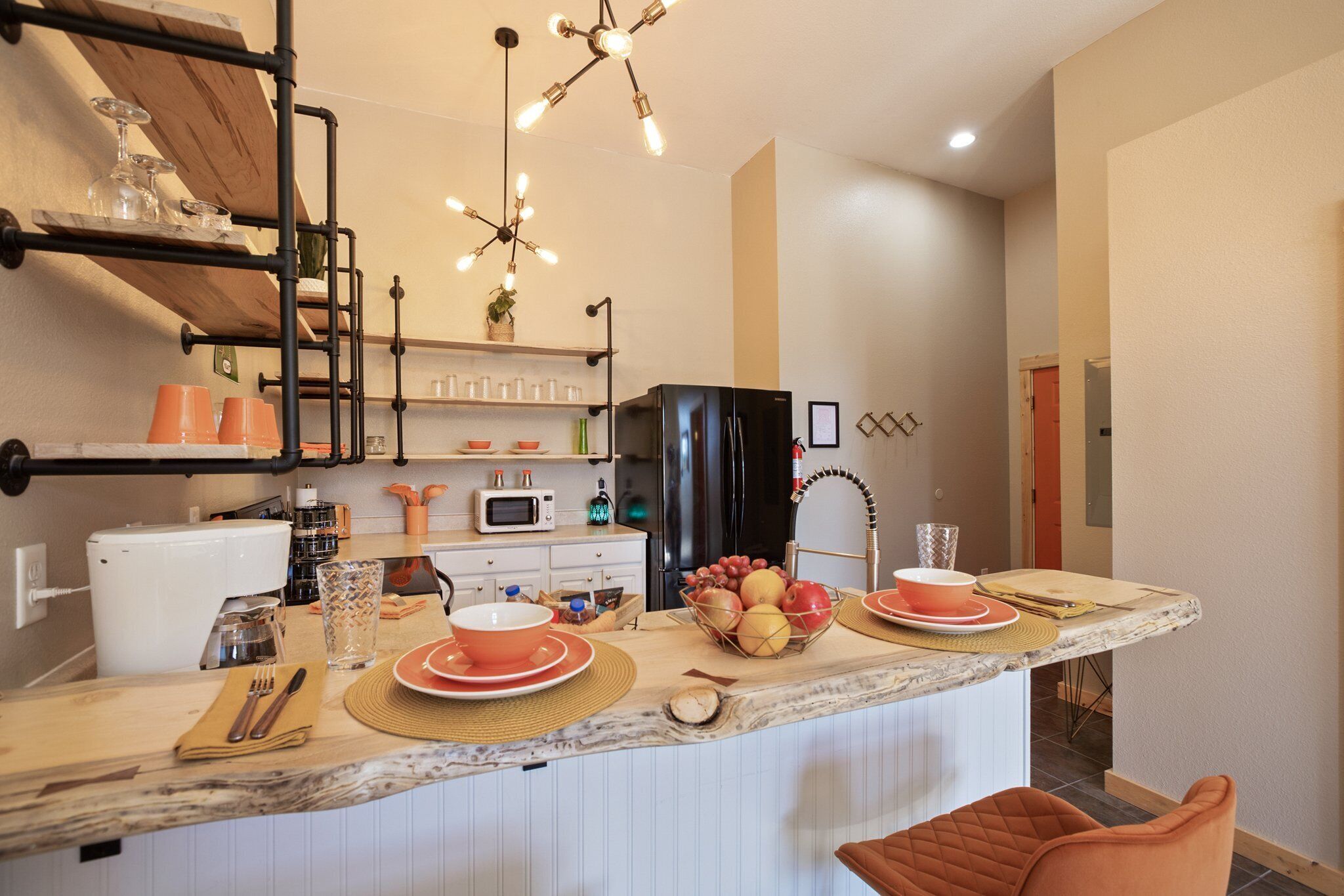 A modern kitchen with a central island, built-in appliances, and a pendant light fixture.
