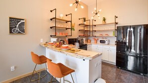 Una cucina moderna con isola centrale, mobili bianchi e frigorifero in acciaio inossidabile.