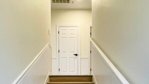 A staircase with white railings and wooden steps leading to a white door at the top. - Great 7 BD walk to the beach + pool (North Myrtle Beach)