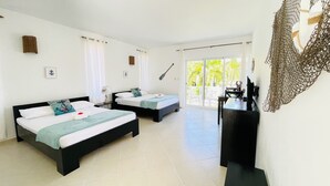 A hotel room with two beds, a desk, and a large window with a view of greenery. - Solaz Boutique Hotel (Las Terrenas)