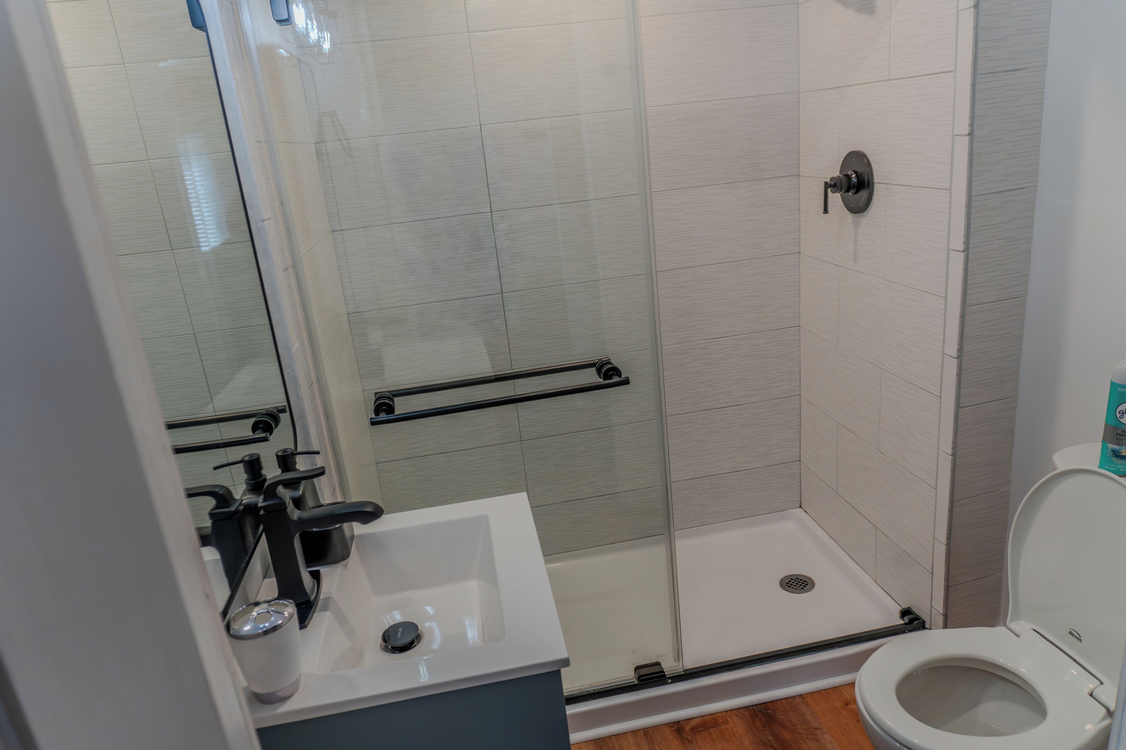 Un baño moderno con ducha, inodoro y lavamanos.