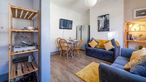 A compact living space with a dining area, a sofa, a TV, and a bookshelf. - Warm and cosy 4 bed house in Clubmoor (Liverpool)