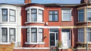 A row of terraced houses with bay windows, a black front door, and a brick facade. - Warm and cosy 4 bed house in Clubmoor (Liverpool)