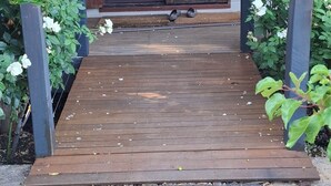 A wooden deck leading to a house with a glass door and a small porch area. - Beautiful room, a comfy king bed, includes a delicious continental breakfast. (Balingup)