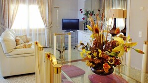 A living room with a sofa, a television, a decorative vase, and a ceiling fan. - Beautiful private villa for 14 people with private pool, WIFI, TV, patio and pets allowed (Miami Platja)