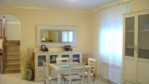 A room with a dining table and chairs, a cabinet with glass doors, a mirror above the table, and a large wardrobe. - Wonderful private villa for 6 guests with private pool, A/C, WIFI, TV, patio and pets allowed (Miami Platja)