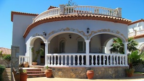 A two-story house with a swimming pool, stone steps, and a balcony with white balustrades. - Wonderful private villa for 6 guests with private pool, A/C, WIFI, TV, patio and pets allowed (Miami Platja)