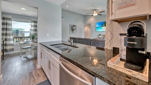 A modern kitchen with a built-in coffee maker, a dining area with a table and chairs, and a view of the outside. - 2nd Floor, Shared Pool Hot Tub, Near Marina, Pickleball courts (Port Aransas)