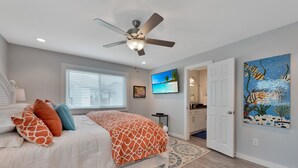 A bedroom with a bed, a ceiling fan, a TV, and artwork on the wall. - 2nd Floor, Shared Pool Hot Tub, Near Marina, Pickleball courts (Port Aransas)