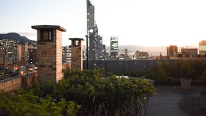 Un giardino pensile con vista sullo skyline cittadino, che include un grattacielo ben visibile.
