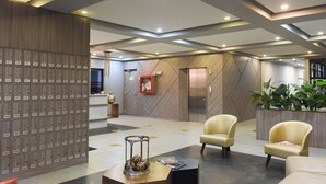 Una hall con una fila di armadietti, una scrivania della reception e due poltrone.