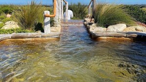 Ein klares Wasserbächlein mit hölzernen Bauwerken an beiden Seiten, das in die Ferne führt.