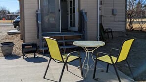A small, single-story building with a porch, a satellite dish, and a barbecue grill. - Cheyenne Cottage- Pet Friendly home, near Northwest College! (Powell)