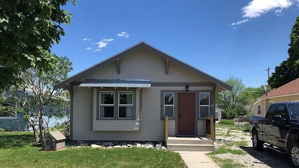 A single-story house with a front porch, a small attached garage, and a driveway. - Cheyenne Cottage- Pet Friendly home, near Northwest College! (Powell)