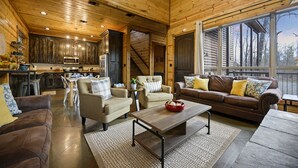 Un vaste espace de vie doté d’un plafond en bois, d’une grande fenêtre et d’un coin salon confortable.