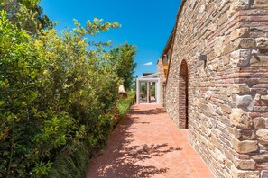 Un bâtiment en pierre avec un chemin dallé menant à une porte d’entrée en verre.