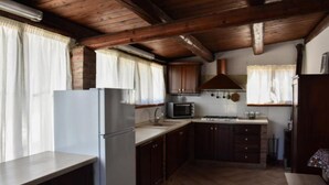 A kitchen with wooden beams, a refrigerator, a microwave, and cabinets. - Casale Cugni with swimming pool for exclusive use - air conditioned - wi-fi (Noto)