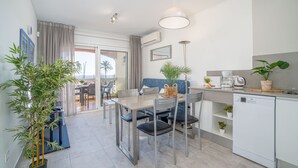 A modern kitchen with a dining area, a dishwasher, and a view of the outdoors. - 0022-BAHIA Apartment in front of the beach with wifi (Empuriabrava)