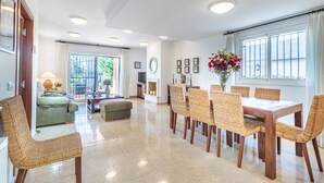 Un salon spacieux comprenant un coin repas, un canapé et un téléviseur.