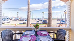 A dining table set for four with a view of a parking lot and palm trees. - 0019-BAHIA Apartment in front of the beach with wifi (Empuriabrava)