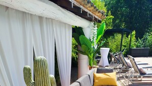 A sunlit outdoor seating area with a sofa, cushions, and a cactus centerpiece. - Exceptional riverside estate 48 pers swimming pool private beaches (La roque sur ceze)