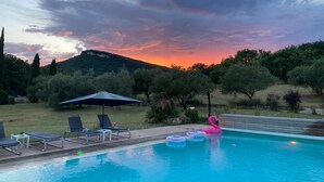A swimming pool with lounge chairs and a flamingo float, surrounded by trees and a hill in the background. - Exceptional riverside estate 48 pers swimming pool private beaches (La roque sur ceze)
