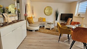 A modern living room with a sofa, chairs, a coffee table, and a TV. - Lounge 1 - Top apartment approx. 75sqm, parking at the house, all in (Koblenz)