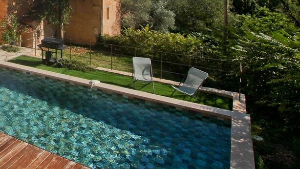 A swimming pool with a wooden deck, a covered seating area, and a view of a stone building. - Your splendid stone farmhouse in the countryside, completely renovated (Cabris)