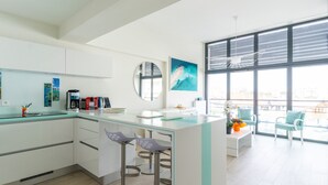 Une cuisine moderne dotée d’un îlot central, de tabourets de bar et d’un coin repas avec des chaises.
