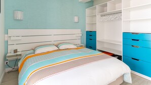 Une chambre à coucher avec un lit, une armoire et une table de chevet.