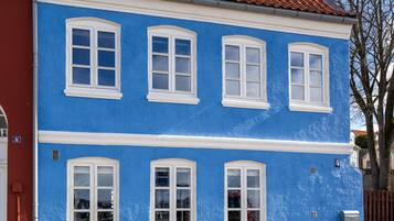Ein zweistöckiges Gebäude mit blauer Fassade und weißen Fensterrahmen.