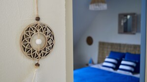 A room with a bed, a hanging light fixture, and a wall-mounted decoration. - La Pichonnière (Isigny-le-Buat)