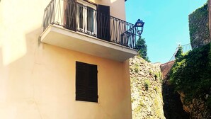 A building with a balcony, a small window, and a stone wall. - Romantic cottage in the historic center of Collepardo (Collepardo)