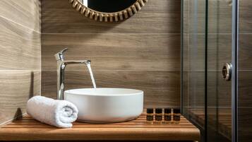 A bathroom with a wooden vanity, a white sink, and a towel.
