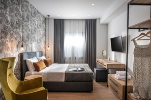 Een moderne slaapkamer met een bed, nachtkastje, televisie en kledingkast.