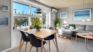 Sala moderna com área de jantar, janelas amplas e vista para o exterior.