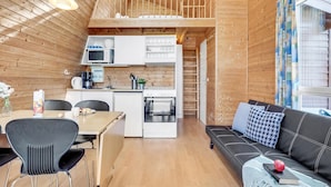 A compact, wooden interior with a kitchenette, dining area, and a sofa. - 1 bedroom cozy home in Fredericia (Fredericia)