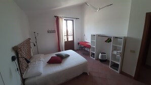 Una camera da letto con un letto, una scrivania, un armadio e una finestra.
