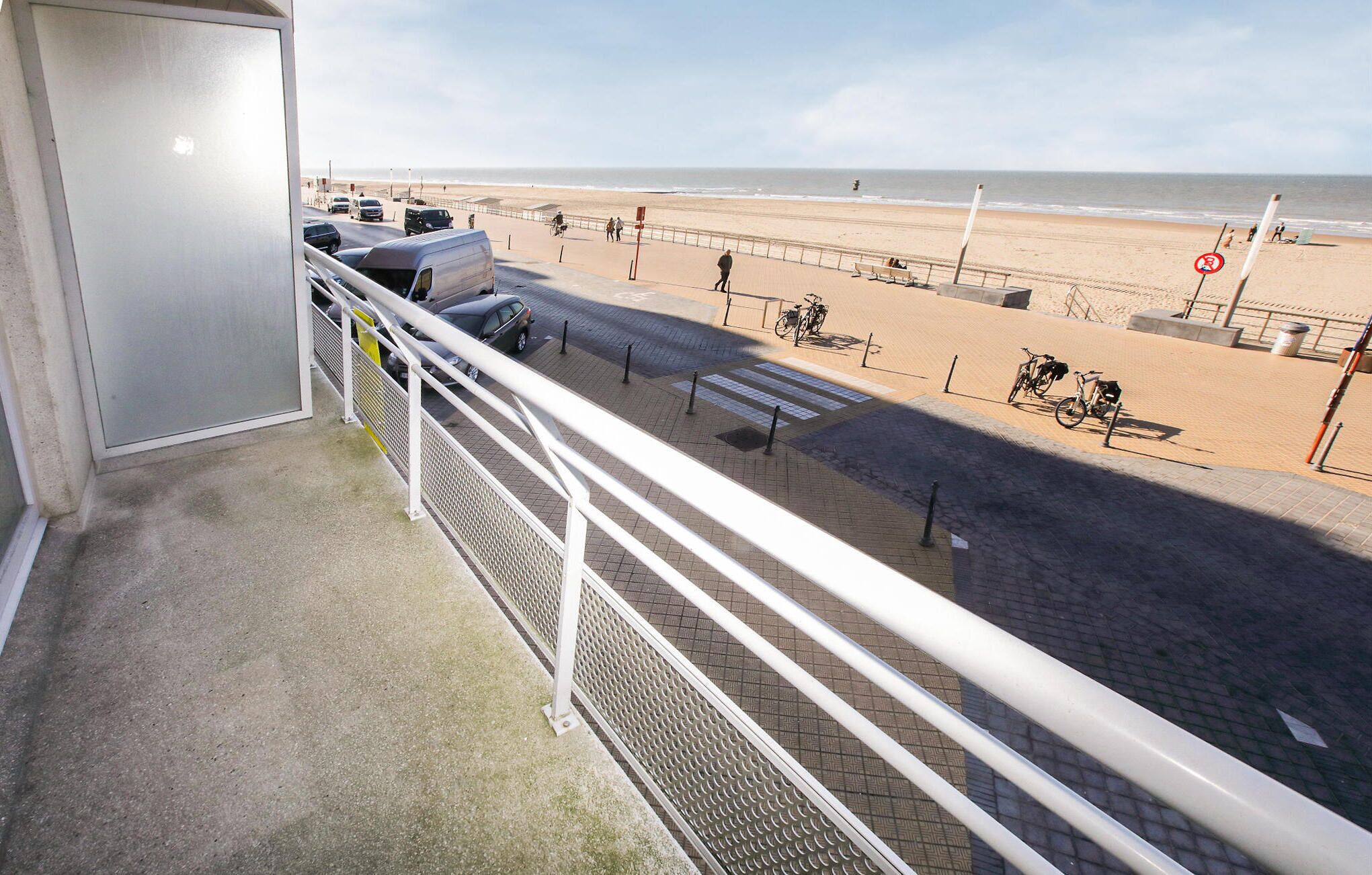 Ein Balkon mit Blick auf einen Strand und das Meer.