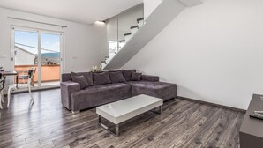 A modern living room with a grey sofa, a white coffee table, and a staircase leading to an outdoor balcony. - Awesome apartment in Kampor with WiFi (Kampor)
