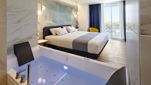 Habitación de hotel moderna con una cama grande, una bañera y vistas a la ciudad.
